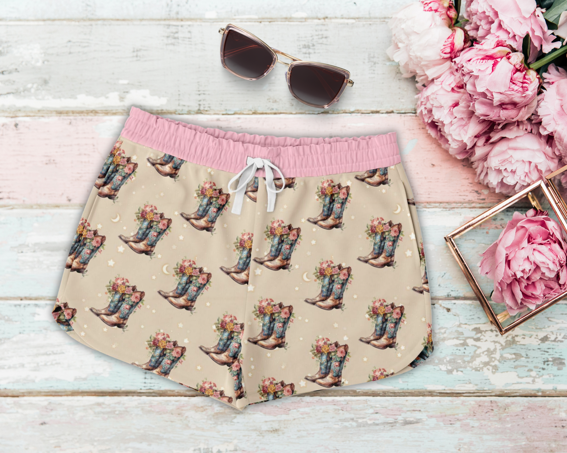 Beige and pink lounge shorts featuring a stars and cowboy boot themed print.